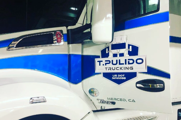 Custom vinyl T. Pulido Trucking door graphic in blue and white