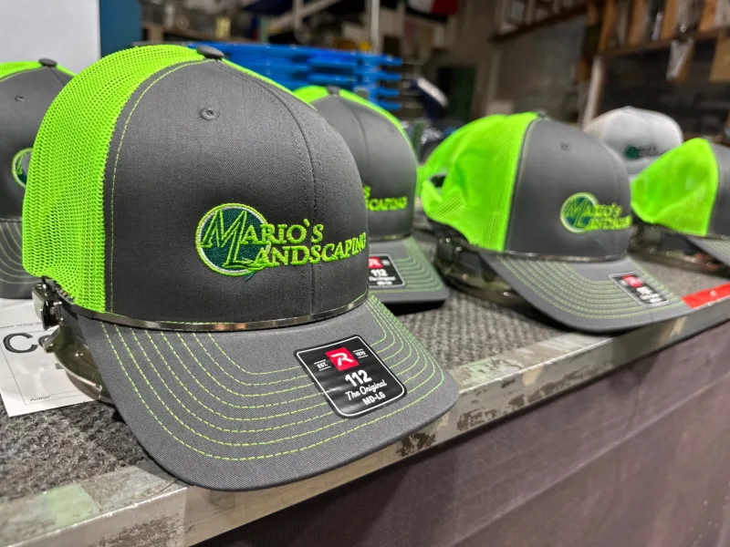 Mario’s Landscaping embroidered gray and neon-green trucker hats